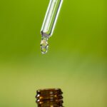 drop-oil-dripping-from-pipette-into-bottle-essential-oil_1252-938